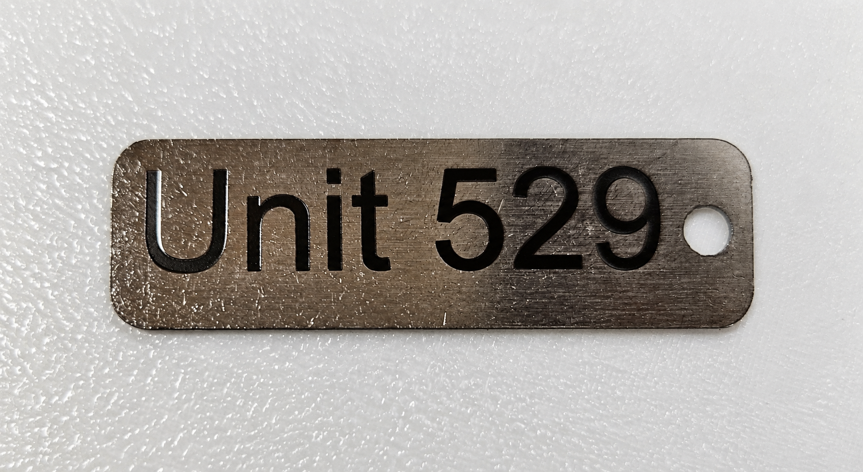 Brushed stainless fleet key tag marked Unit 529
