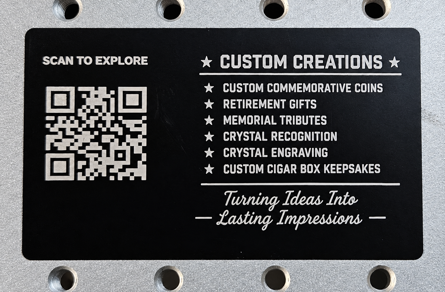 Back of a black aluminum business card with custom creations list and website QR code